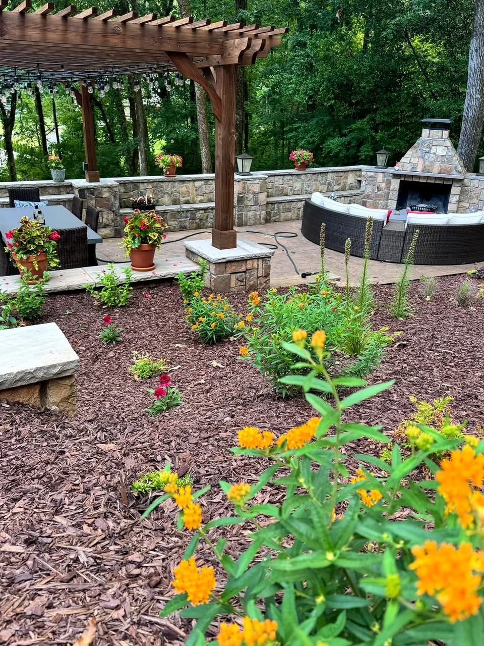 Outdoor living space with pergola, fireplace and integrated planting