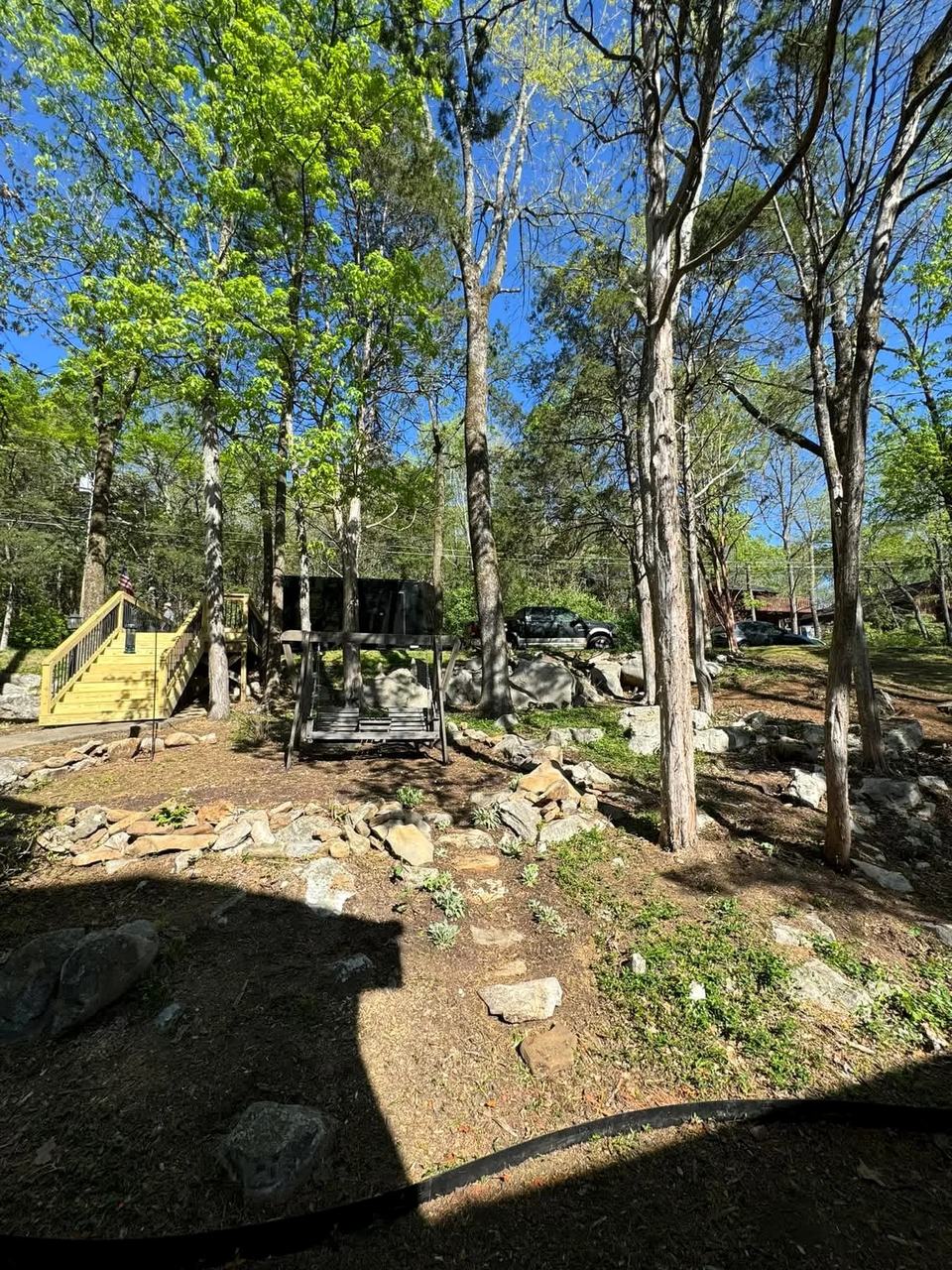 Restored wooded residential slope with opened sightlines and retained natural stone